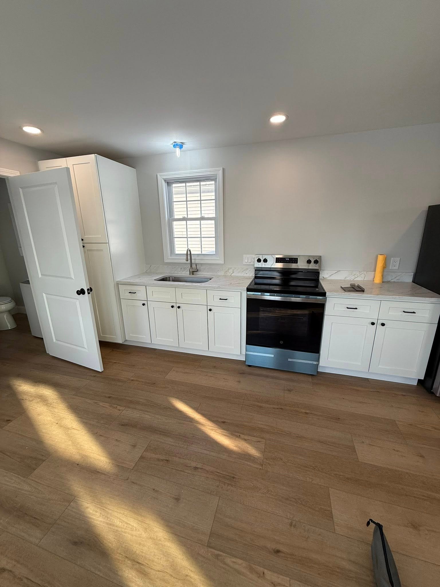 Kitchen remodel with updated cabinets, counters, and lighting